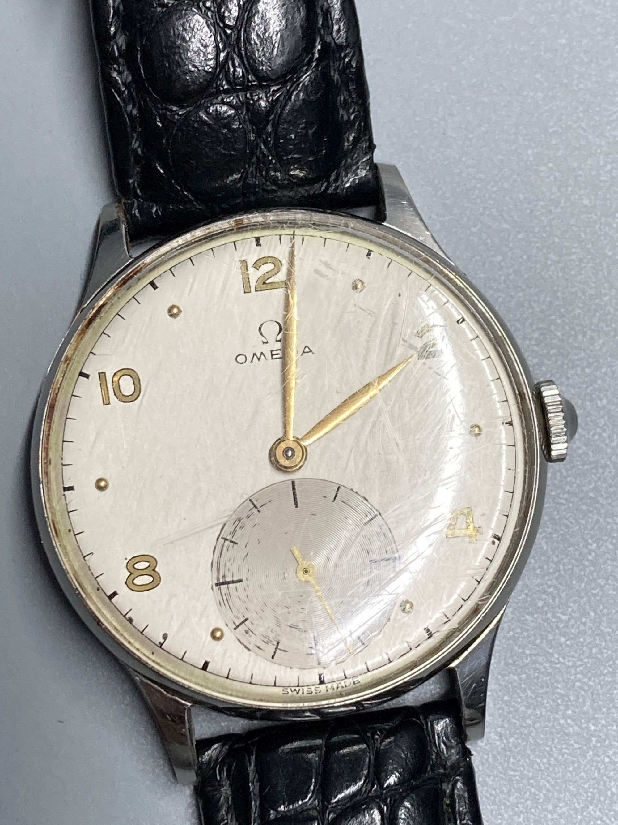 A gentlemans 1940s? stainless steel Omega manual wind wrist watch, with Arabic and dot numerals